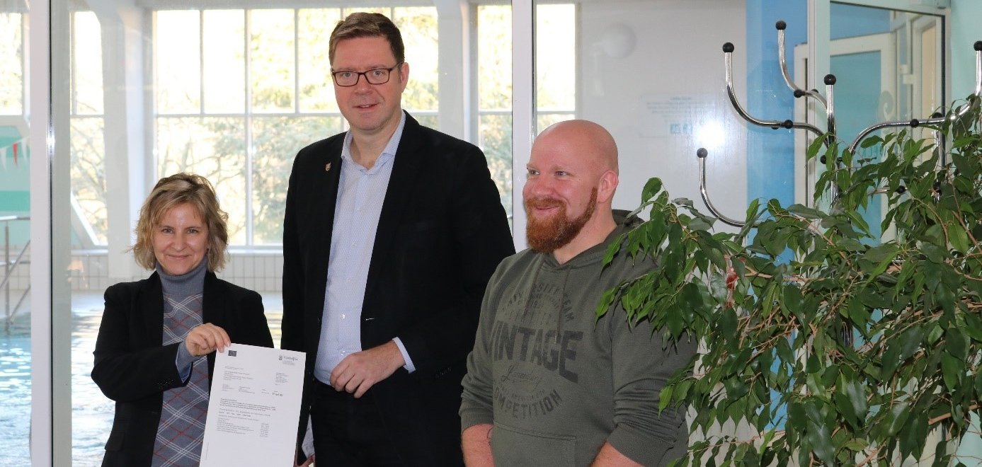 Klimaschutz- und Energieministerin Katrin Eder (links) überreicht EFRE-Förderbescheid in Höhe von rund 873.000 Euro an Bürgermeister Marcus Heintel (Mitte) und den Bäderbetriebsleiter Daniel Schön (rechts) – Moseltherme Traben-Trarbach energetisch saniert